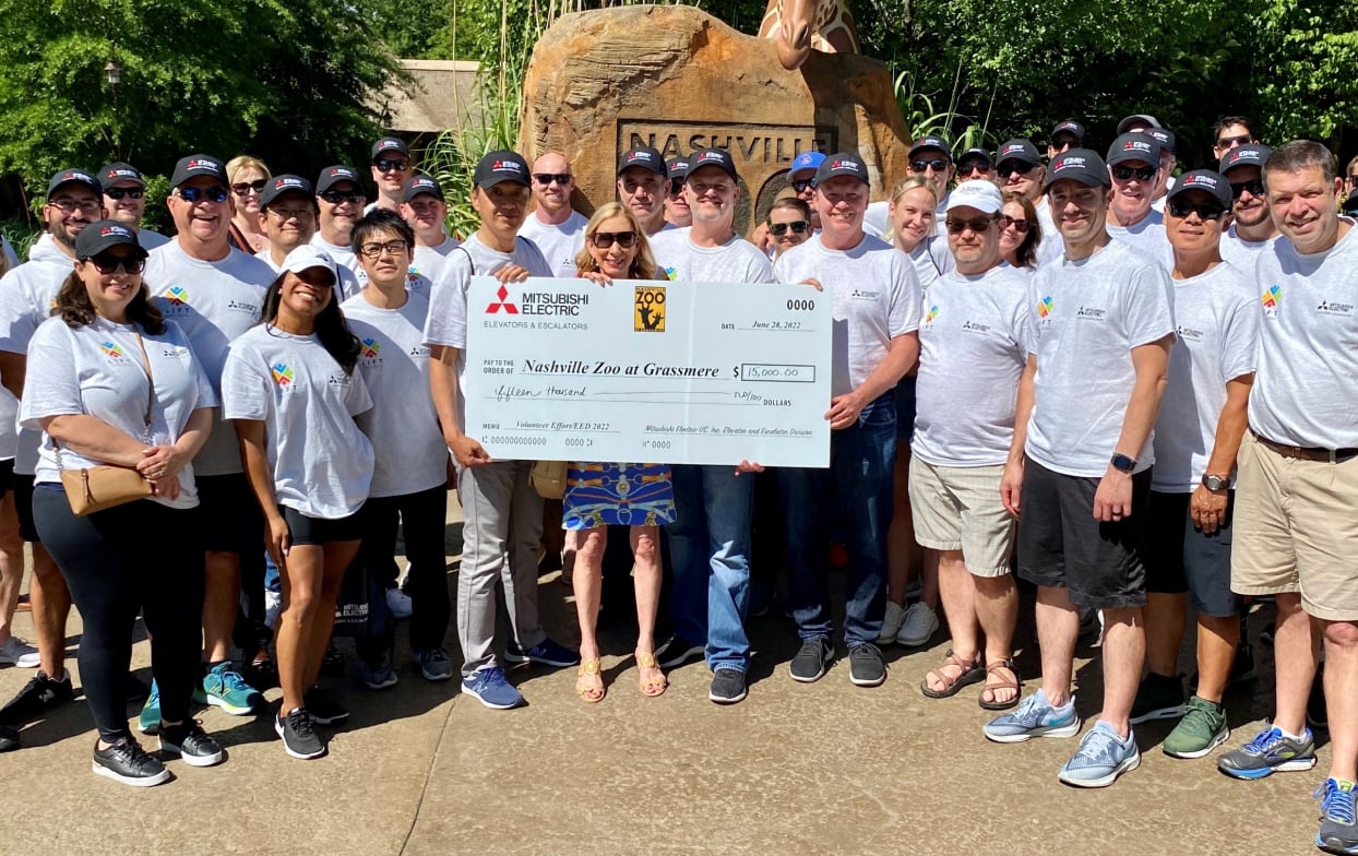 Group of people from the Nashville Zoo holding a check from Mitsubishi Electric.